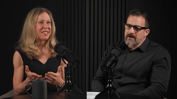 Una mujer rubia, la Dra. Marie-Pierre St-Onge, y un hombre con barba y gafas, sentados frente a micrófonos. La mujer gesticula mientras habla