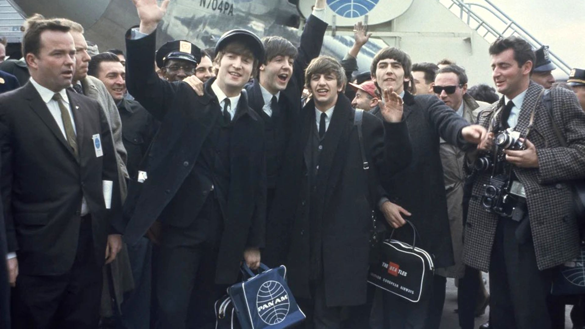 Los Beatles, John Lennon, Paul McCartney, George Harrison y Ringo Starr, saludan a la multitud emocionada tras aterrizar en el aeropuerto JFK de Nueva York para su primera gira estadounidense (AP)