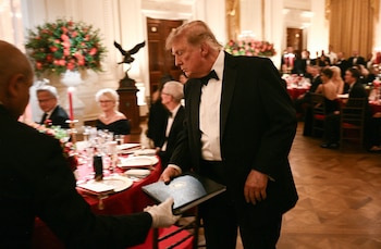 El presidente de Estados Unidos, Donald Trump, toma unos documentos mientras recibe al presidente de China, Xi Jinping, para una cena de Estado en el Salón Este de la Casa Blanca, en Washington D. C., el 24 de septiembre de 2026. El presidente Xi realiza una visita de Estado a Estados Unidos del 23 al 25 de septiembre (SMIALOWSKI/AFP)