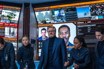 Colin Firth, en el centro, en una escena de "Disclosure Day". (Niko Tavernise/Universal Pictures and Amblin Entertainment via AP)