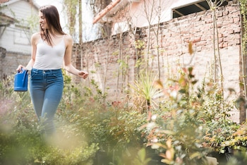 Una mujer regando las plantas de su jardín
