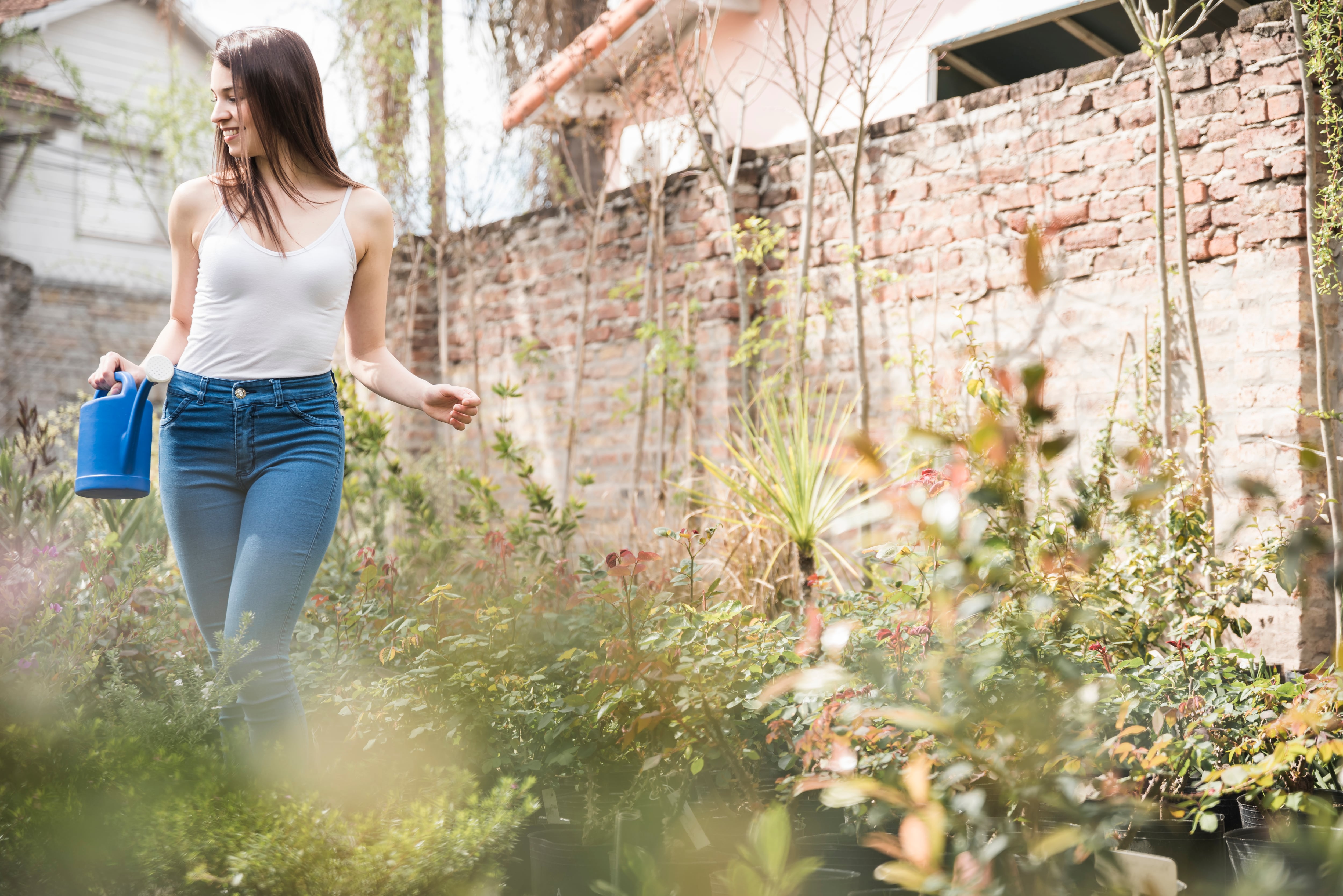 Mujer en su jardín. (Magnific)
