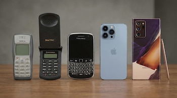 Cinco teléfonos móviles alineados: Nokia 1100, Motorola StarTAC plegado, BlackBerry con teclado QWERTY, iPhone azul, y Samsung Galaxy Note bronce con lápiz.