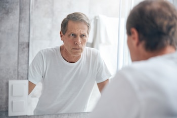 Un hombre frente al espejo.