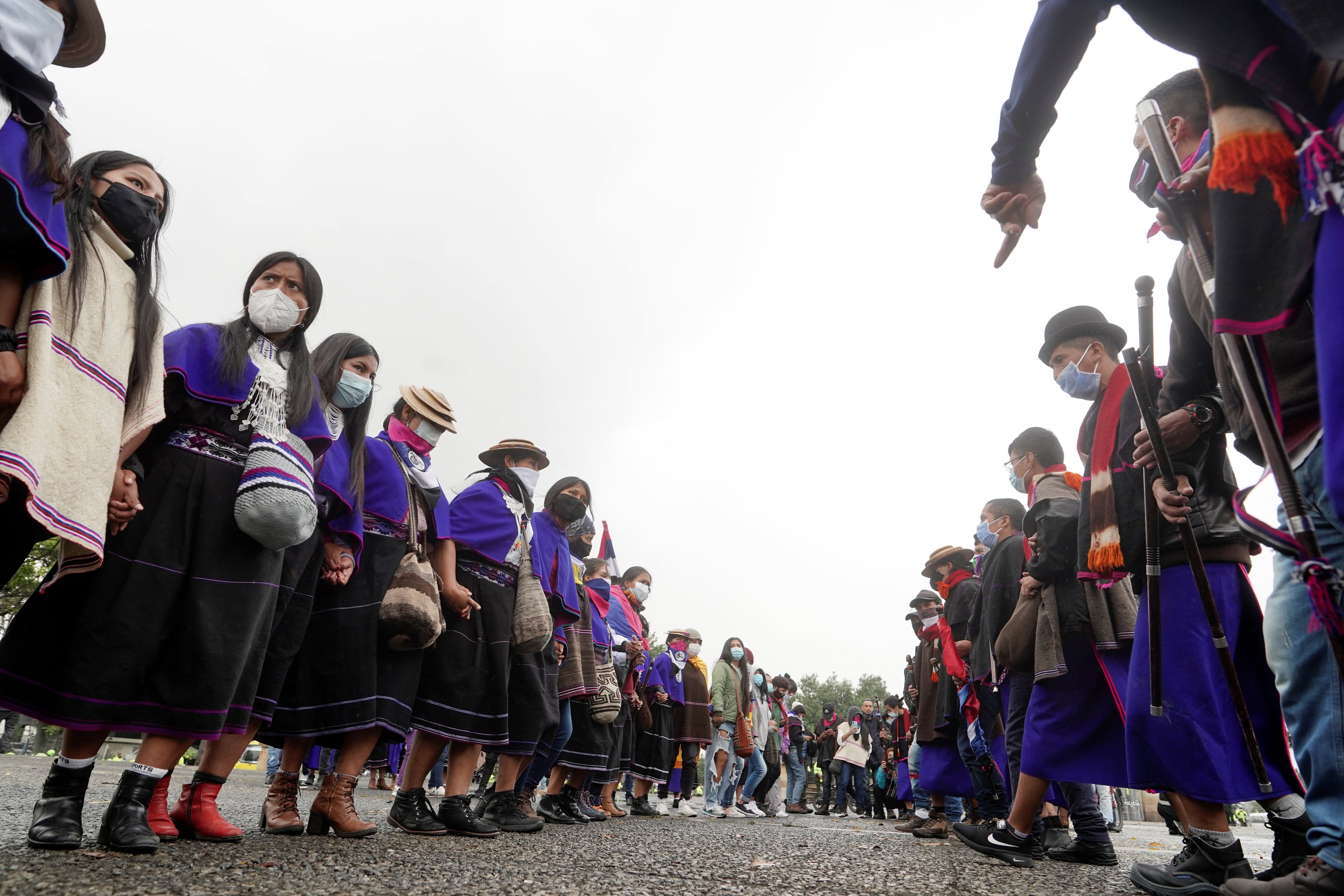 Misak indigenous people dance after trying to topple a statue of Italian explorer Cristopher Columbus during protests against the government, in Bogota, Colombia June 9, 2021. REUTERS/Nathalia Angarita