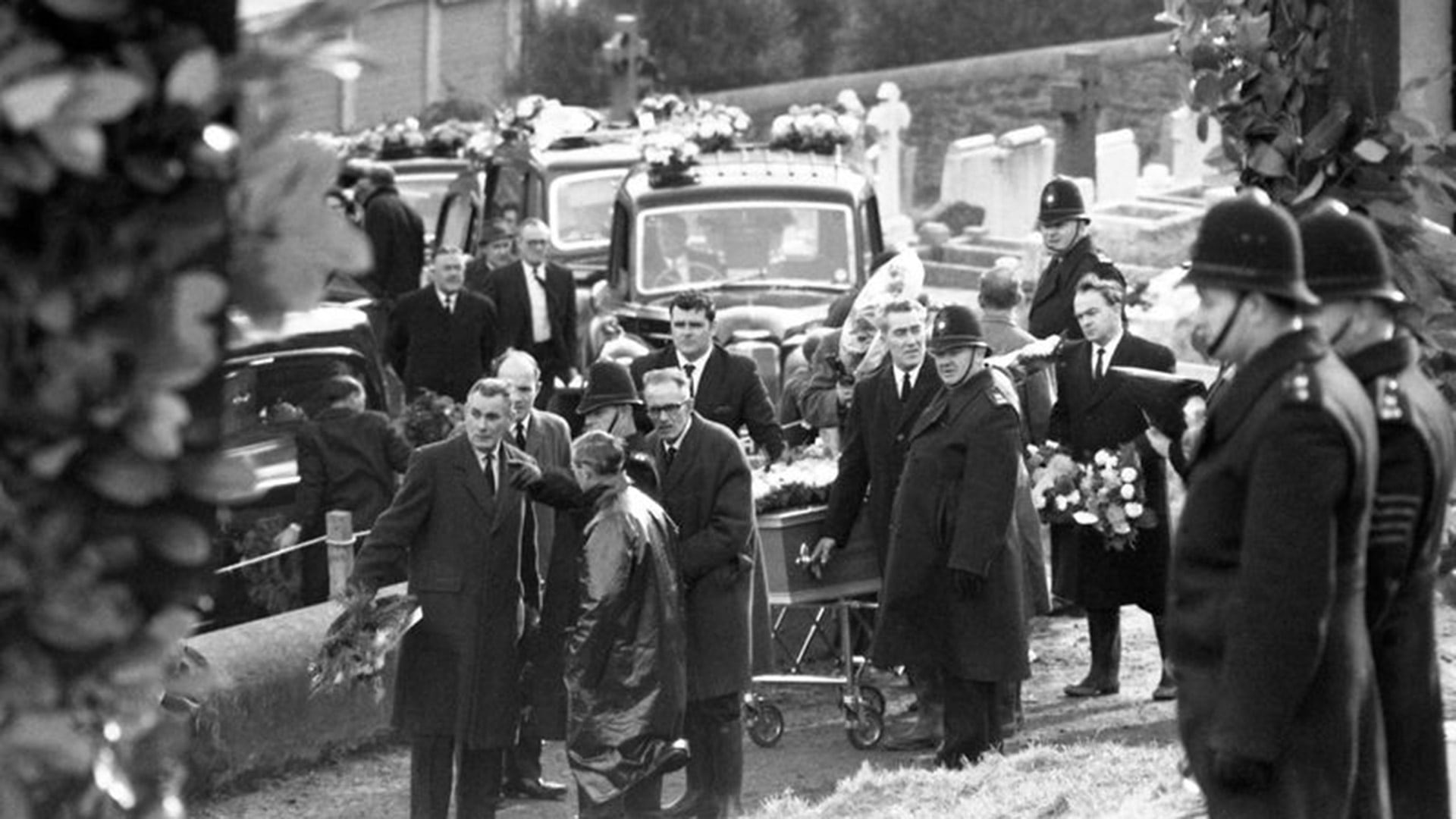 Largas comitivas fúnebres avanzan hacia el cementerio de Bryntaf, en Aberfan (Gales), mientras los ataúdes de los niños son depositados junto a la fosa común, el 27 de octubre de 1966 (Associated Press)