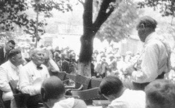 El fiscal acusador William Jennings Bryan (sentado a la izquierda, abanicándose) es confrontado por el abogado defensor Clarence Darrow (de pie a la derecha) durante la célebre sesión al aire libre del 20 de julio de 1925