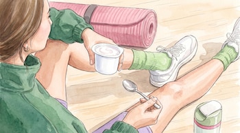 Ilustración de una mujer sentada en el suelo que sostiene un vaso de yogur blanco y una cuchara junto a una esterilla rosa.
