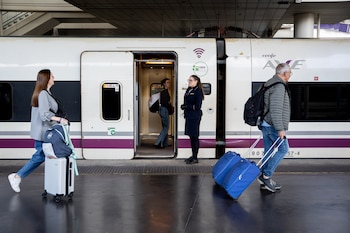 Viajeros suben a bordo de un AVE dirección Málaga desde Atocha, Madrid.