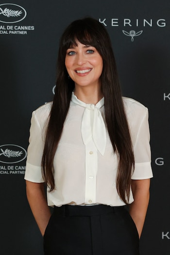 La camisa blanca semitransparente con lazo ancho de Dakota Johnson introduce elegancia y delicadeza, convirtiéndose en un referente de sofisticación sutil en las tendencias actuales (REUTERS/Stephane Mahe)