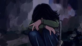 Ilustración de una persona con cabello oscuro, suéter verde y pantalón azul que permanece sentada en una silla con el rostro oculto.