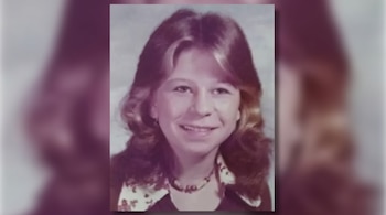 Retrato en primer plano de una joven sonriente con cabello castaño a los hombros, collar y camisa con cuello estampado.