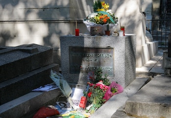 Flores y velas adornan la tumba del legendario vocalista de The Doors, Jim Morrison, en el cementerio Pere Lachaise, el lunes 3 de julio de 2011, en París. (AP Foto/Jacques Brinon, Archivo)