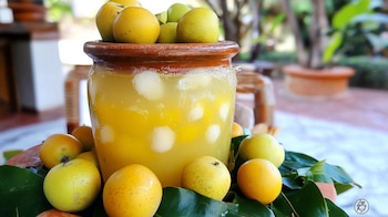 Vaso transparente con agua de nanche, hielos y nanches frescos flotando, sobre mesa rústica. – (Imagen Ilustrativa Infobae)