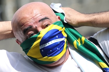 Un brasileño se tapa la boca con una bandera en San Pablo (REUTERS/Rahel Patrasso)