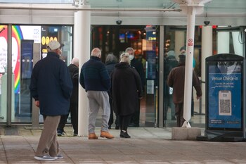 Personas hacen cola para recibir