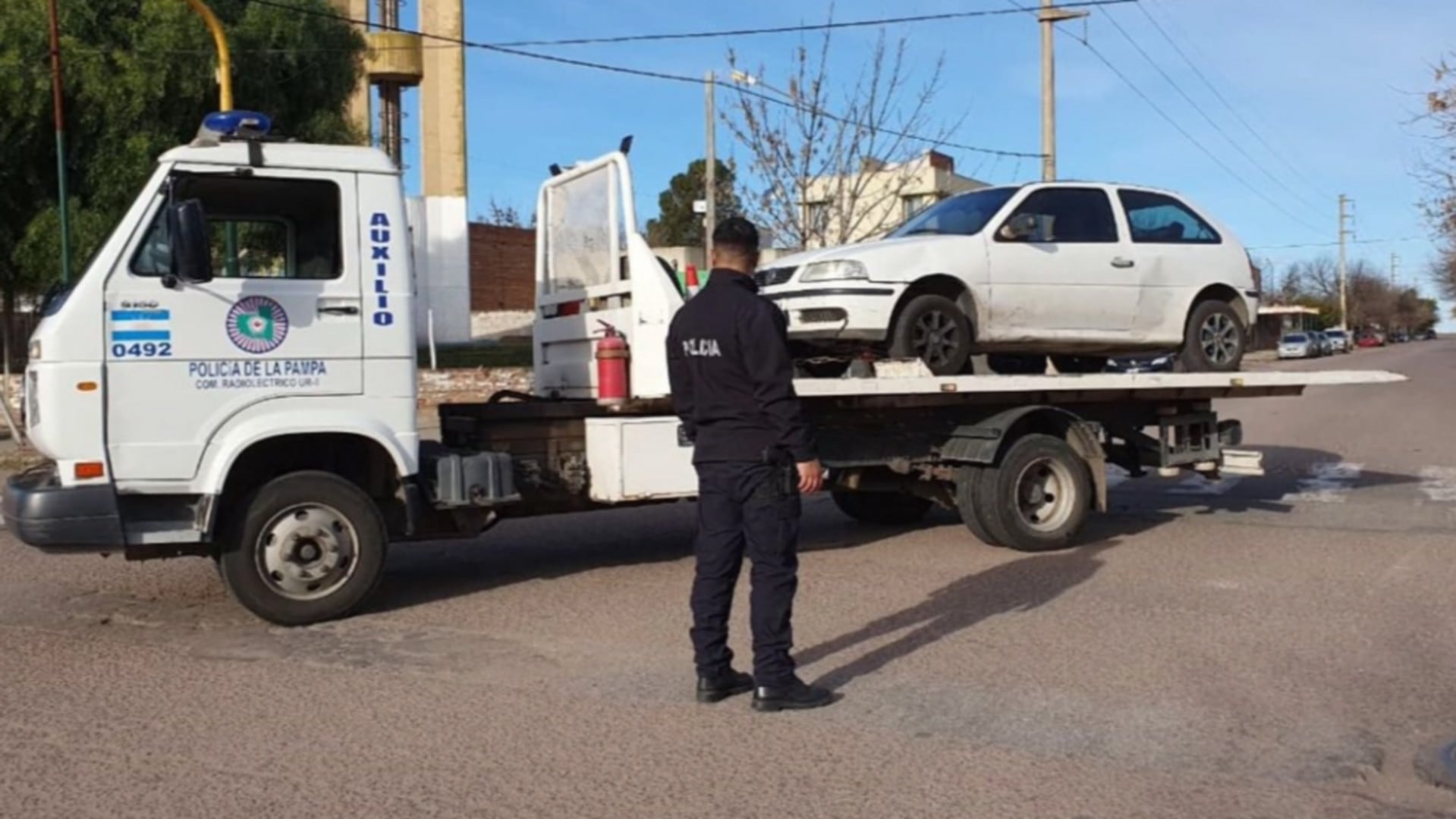 Un vehículo blanco, presuntamente involucrado en una persecución policial y choque con hallazgo de drogas, es trasladado por una grúa de la Policía de La Pampa en General Pico. (La Arena)