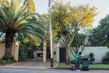 A waste-picker sorts through a bag of garbage from bins placed outside a gated residence in a wealthy suburb of Johannesburg, South Africa, on Friday, May 3, 2019. A legacy of apartheid, inequality remains so ingrained the ruling African National Congress hasnt been able to narrow the wealth gap since taking power 25 years ago.