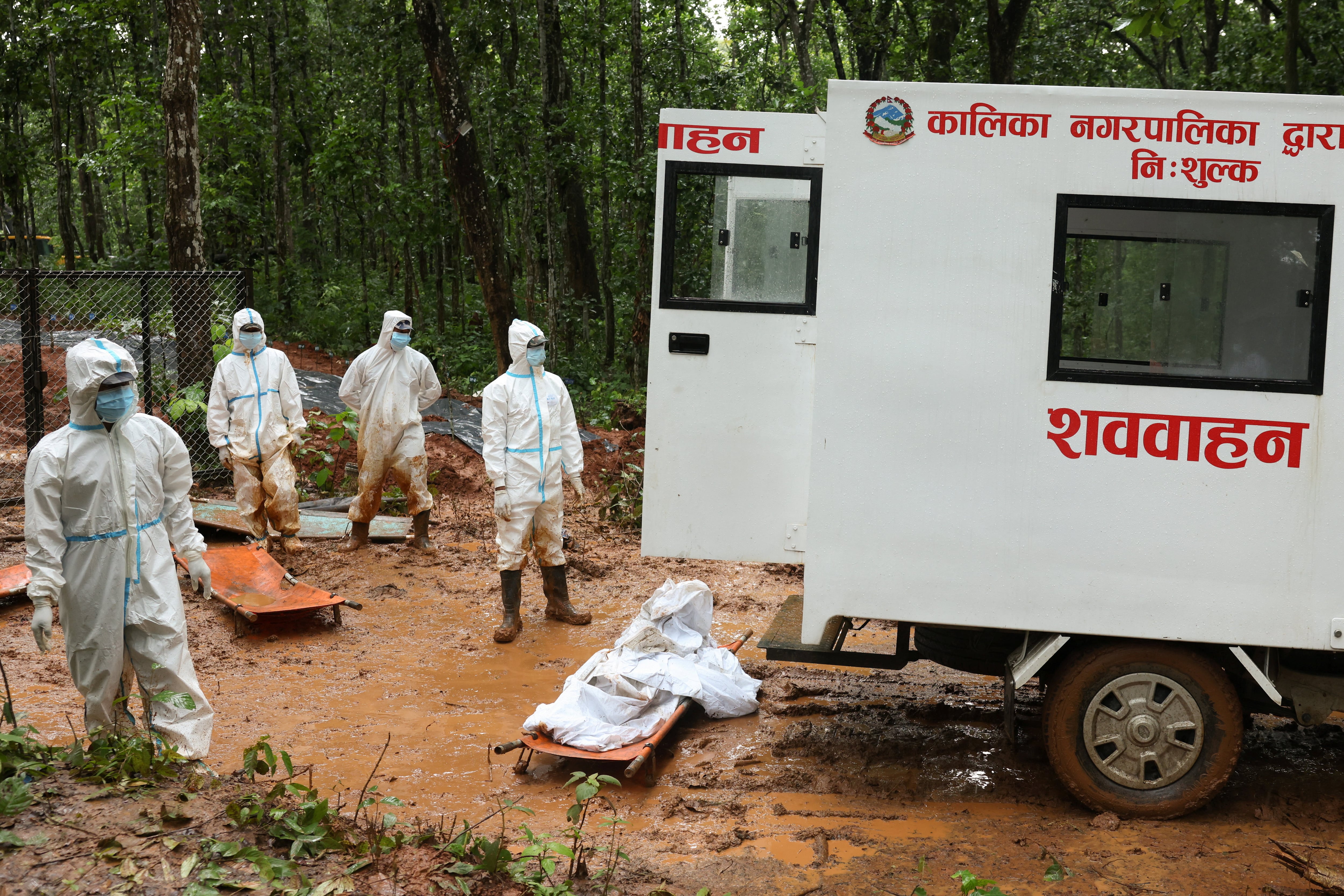 Agentes de la Fuerza de Policía Armada (APF) esperan para trasladar un cuerpo a la fosa común de Devghat, lugar de entierro masivo para las víctimas de las mortales inundaciones repentinas y deslizamientos de tierra en Chitwan, Nepal, el 1 de septiembre de 2026. REUTERS/Adnan Abidi