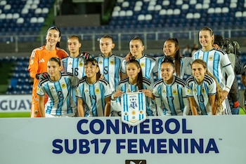 Cuatro jugadoras de fútbol femenino en el campo. Dos de Brasil con camisetas amarillas y shorts azules, dos de Argentina con camisetas celestes y blancas a rayas