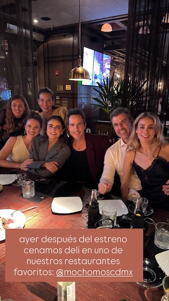 Ocho personas, cinco mujeres y tres hombres, sentadas en una mesa de restaurante. Se aprecian copas, botellas, platos y cubiertos