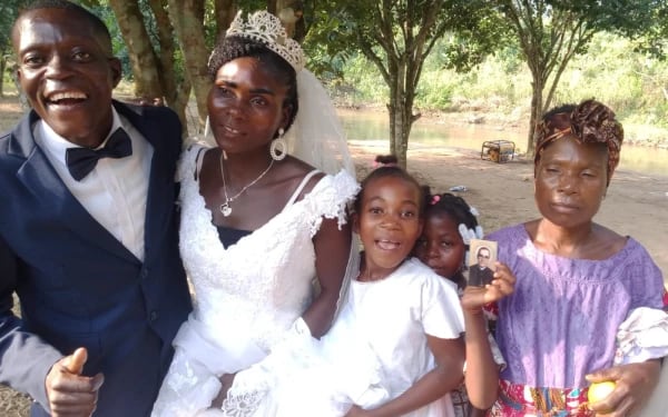 Una niña angoleña muestra una imagen de Monseñor Óscar Romero en una boda en la capilla que lleva su nombre en Angola. Crédito: Padre Edmundo Aguilera.