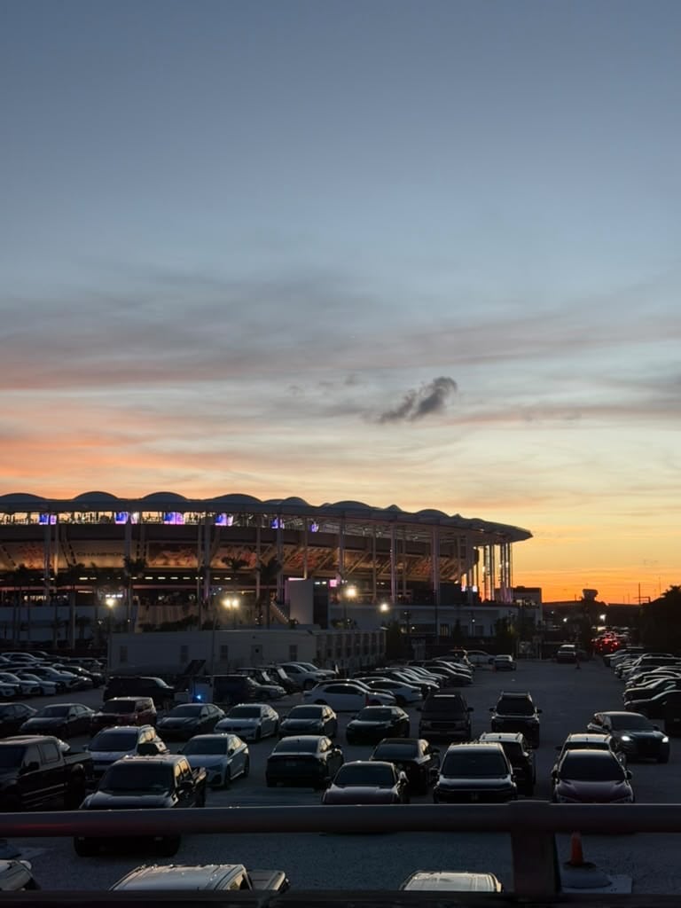 Vista nocturna del Chase Stadium, sede del Inter Miami, desde el estacionamiento repleto de autos