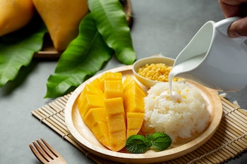 Mango con arroz pegajoso hecho con leche de coco, una receta dulce típica de Tailandia (Magnific)