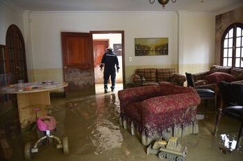 Un bombero camina dentro de una casa con barro después de que el río se desbordara debido a fuertes lluvias, en La Paz, Bolivia (REUTERS/Claudia Morales)