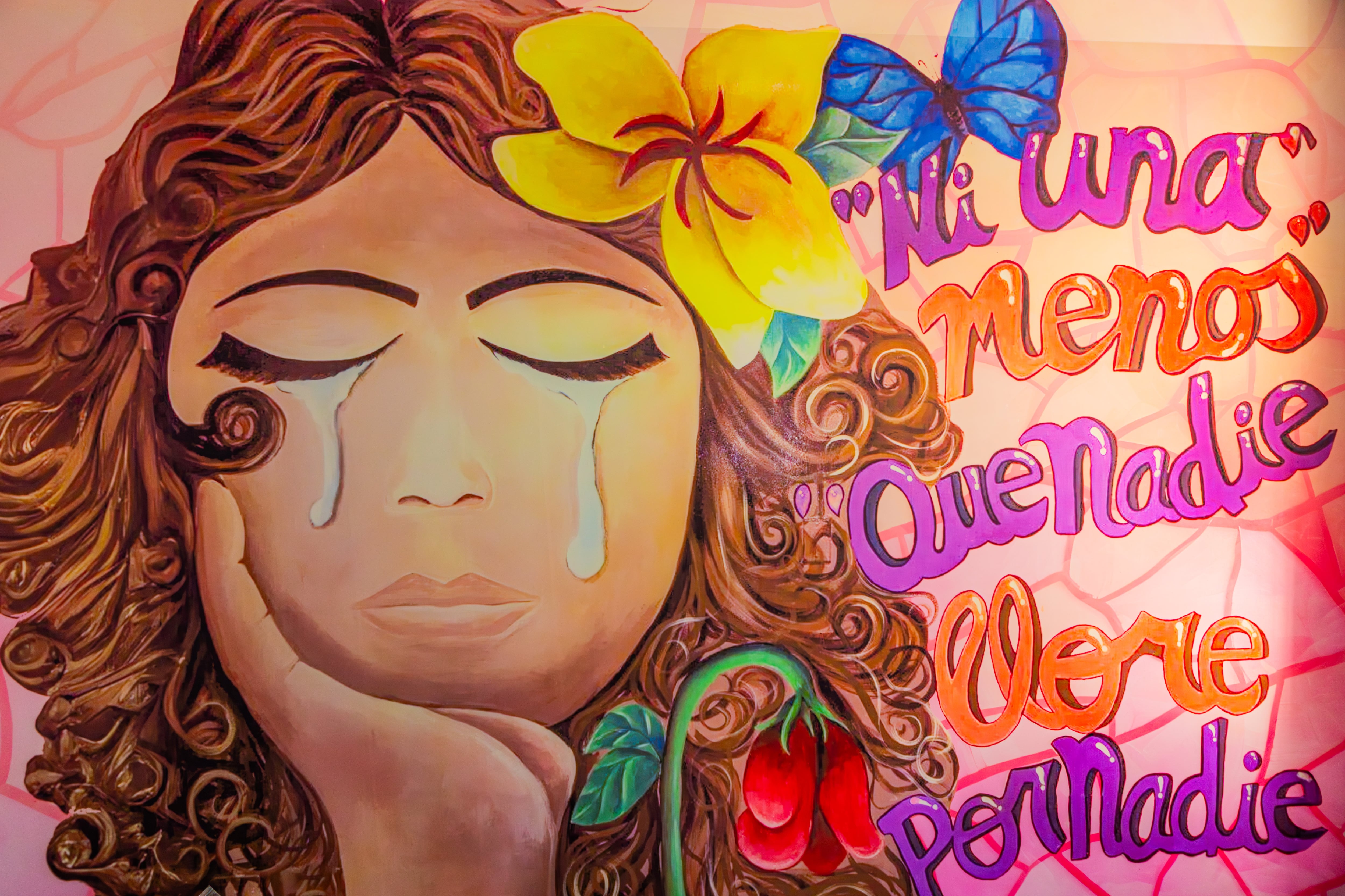 Un mural vibrante con una mujer llorando y las frases