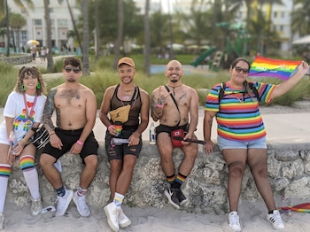 Un grupo de jóvenes descansa recostado a un muro durante el Stonewall Pride Parade en Wilton Manors, Miami.