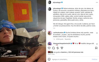Captura de red social con una mujer acostada en cama con una compresa fría en la frente y un gato, junto al texto de su publicación