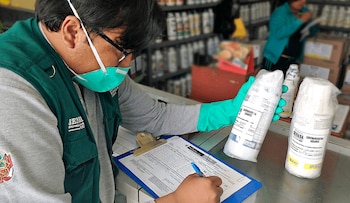 Hombre trabajador de Senasa viendo producto y llenando datos sobre este