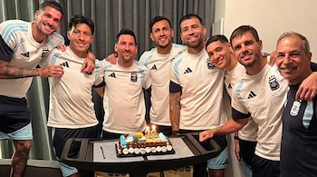 Ocho hombres, incluidos Lionel Messi, posan sonrientes con camisetas blancas y celestes de la Selección Argentina junto a una tarta de cumpleaños con velas 39.