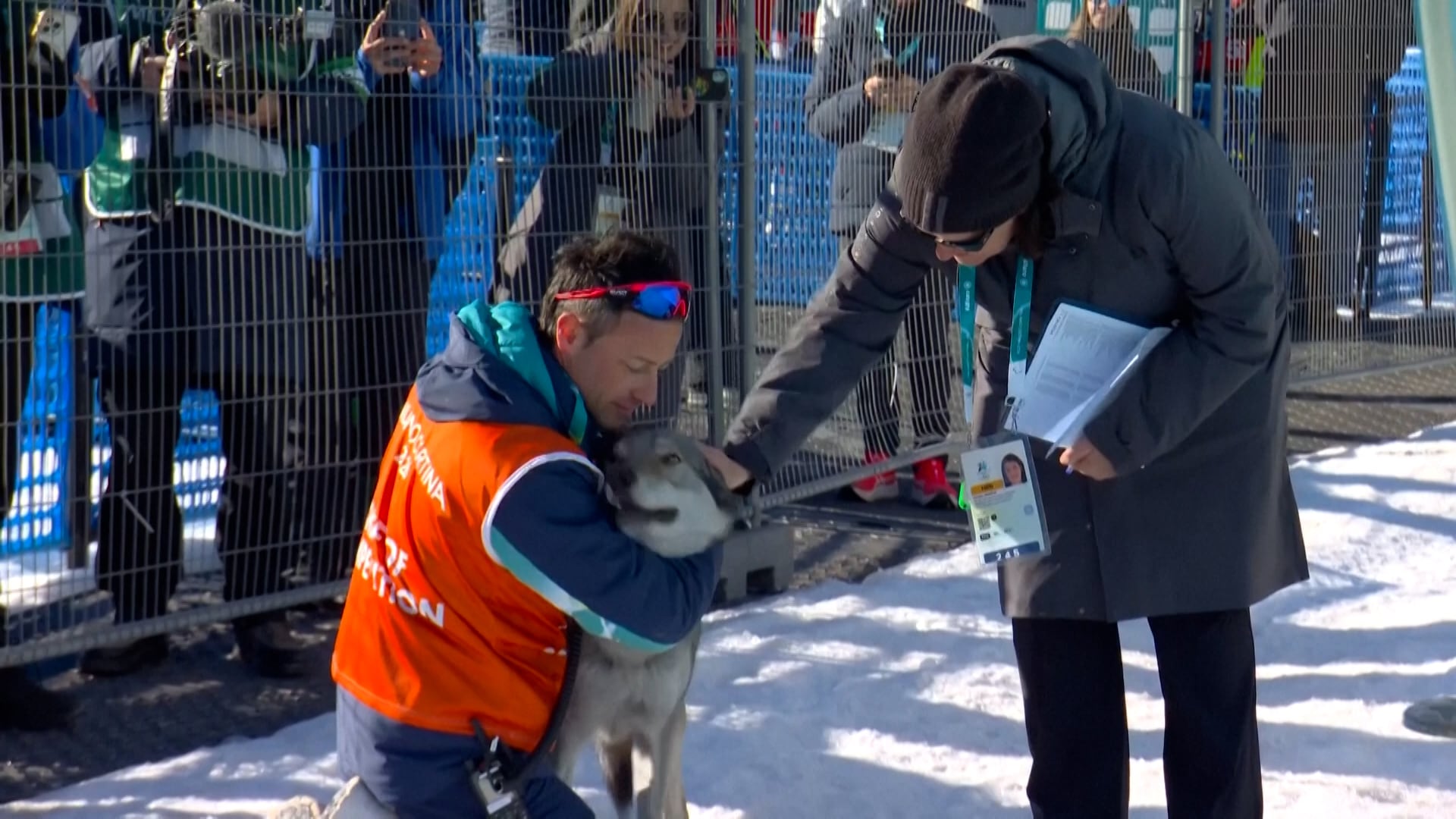 Un voluntario abraza al perro que se coló en la pista de esquí durante los Juegos Olímpicos de Invierno