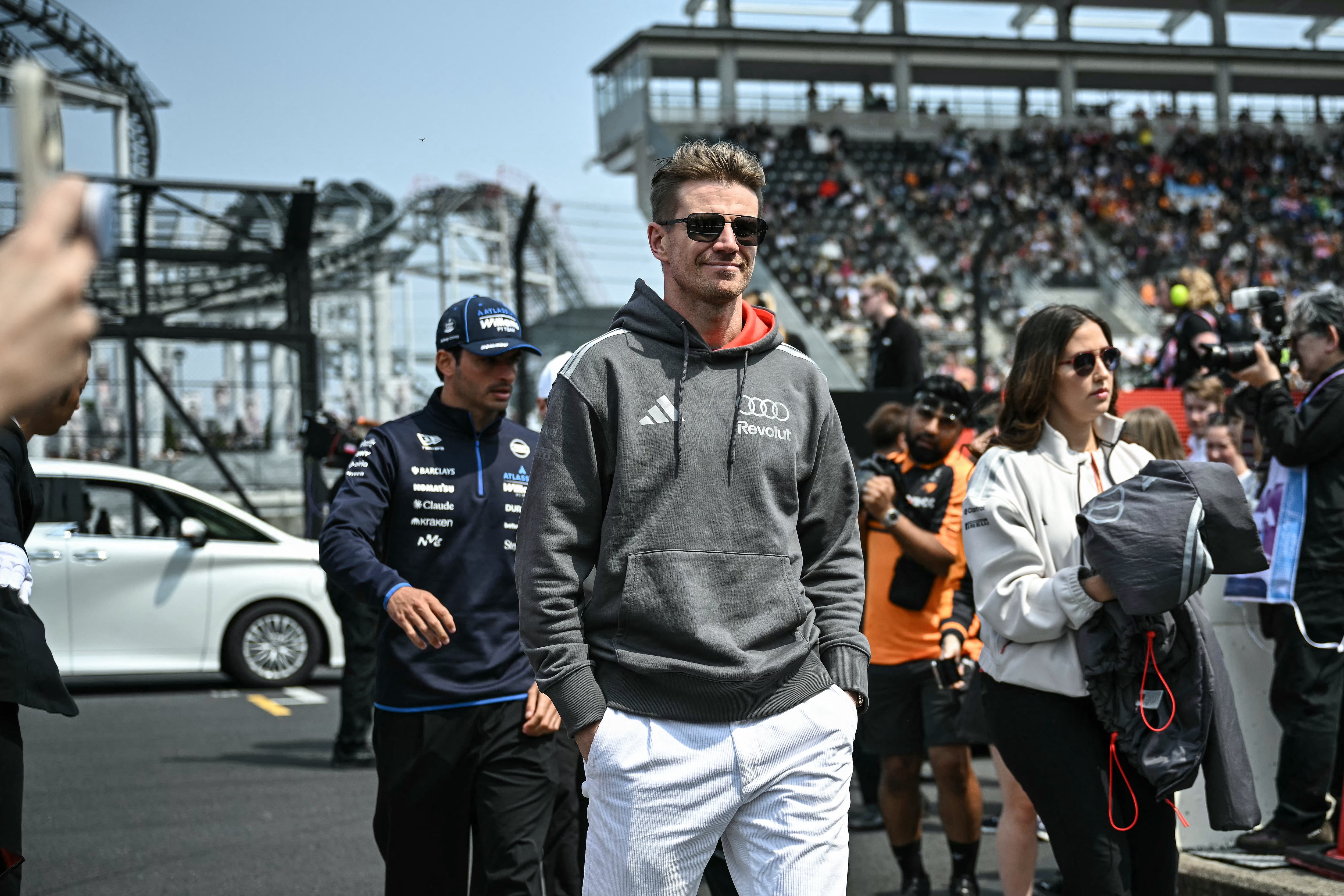 Nico Hülkenberg opta por una sudadera gris con logos de Audi y Revolut, combinada con pantalones blancos y gafas de sol rectangulares (AFP)