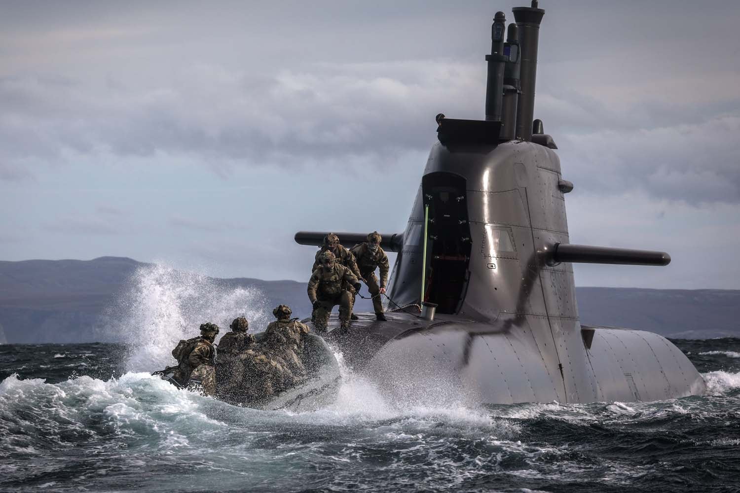 Comandos británicos se despliegan desde un submarino alemán hacia un bote de asalto durante el ejercicio militar Strike Warrior en las costas de Escocia. (Royal Navy)
