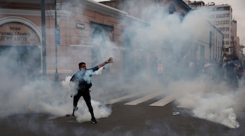 Un partidario del expresidente Martín Vizcarra permanece en medio de gases lacrimógenos disparados por la policía que impide que los manifestantes lleguen al Congreso mientras los legisladores toman juramento a Manuel Merino como nuevo presidente en Lima, Perú, el martes 10 de noviembre de 2020. (AP Foto/Rodrigo Abd)