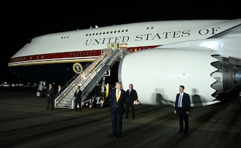 Donald Trump saluda frente al Air Force One luego de hacer el pase de aviones en la base de la Royal Air Force británica en Mildenhall. Desde allí se embarcó en el nuevo avión a los Estados Unidos y habló con los periodistas a bordo (Photo by SAUL LOEB / AFP)