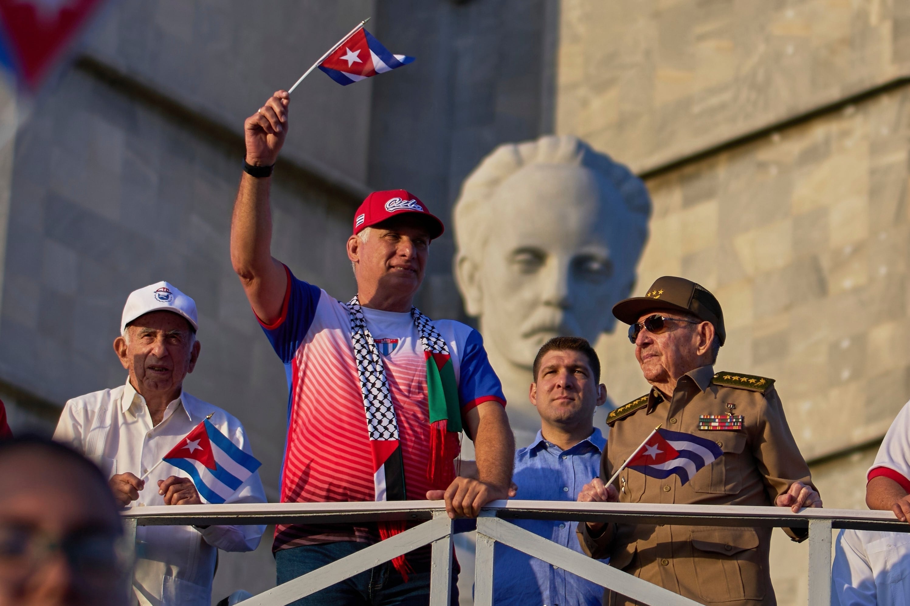 El dictador de Cuba Miguel Diaz-Canel ondea una bandera cubana mientras mira el desfile del Día del Trabajo junto a Raúl Castro, segundo de derecha a izquierda, y Raul Guillermo Rodríguez Castro, nieto de Raúl Castro, en la Plaza de la Revolución en La Habana, el 1 de mayo de 2025 (AP/Ramon Espinosa, Archivo)