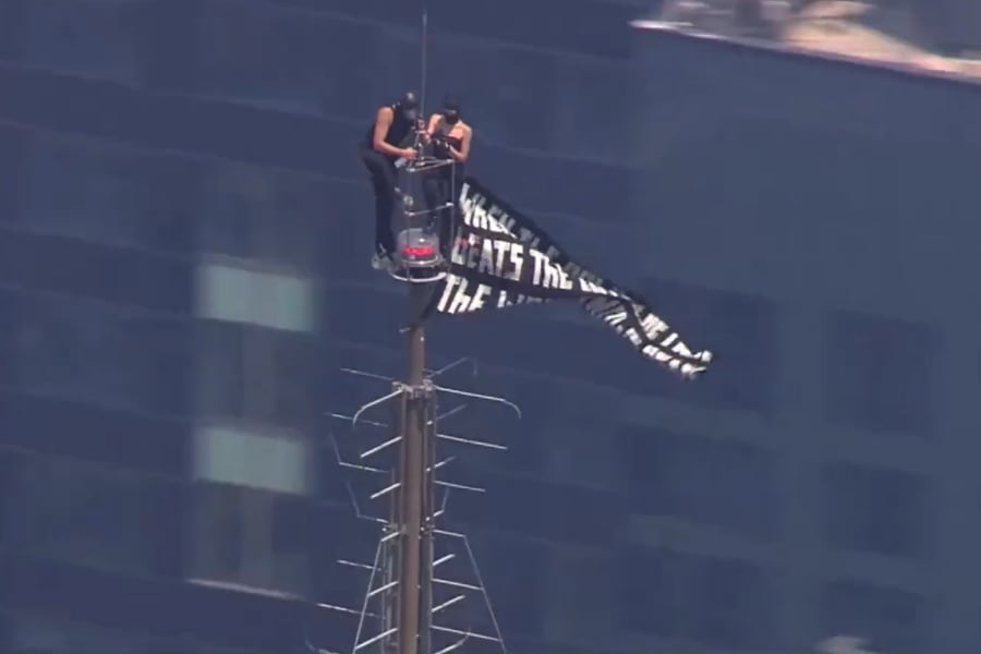Dos activistas despliegan una pancarta con un mensaje a favor de la paz desde la antena del Empire State Building en Nueva York (Captura de video: Fox News).