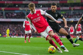 Martin Odegaard, del Arsenal regatea con el balón mientras lo intenta defender Ryan Fredericks del Bournemouth en el encuentro de la Liga Premier el sábado 4 de marzo del 2023. (AP Foto/Kin Cheung)