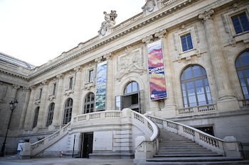Fachada de piedra con una escalinata de entrada y dos carteles publicitarios de la exposición Cezanne et nous