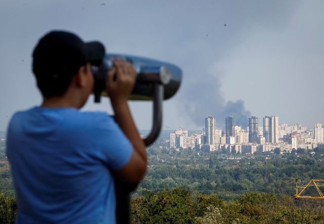Un niño observa el humo que se eleva sobre la ciudad durante un ataque ruso con drones, en Kiev (REUTERS/Gleb Garanich)