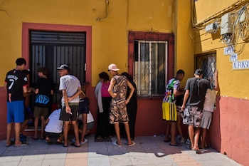 Varios migrantes, algunos de ellos menores no acompañados, que cruzaron desde Marruecos hacia Ceuta, escriben su información de contacto para dársela a una asociación vecinal. (AP Foto/Bernat Armangue)