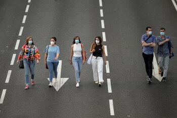 People wearing protective face masks walk along Paseo de la Castellana avenue amid the coronavirus disease (COVID-19) outbreak, in Madrid, Spain, May 30, 2020. REUTERS/Javier Barbancho
