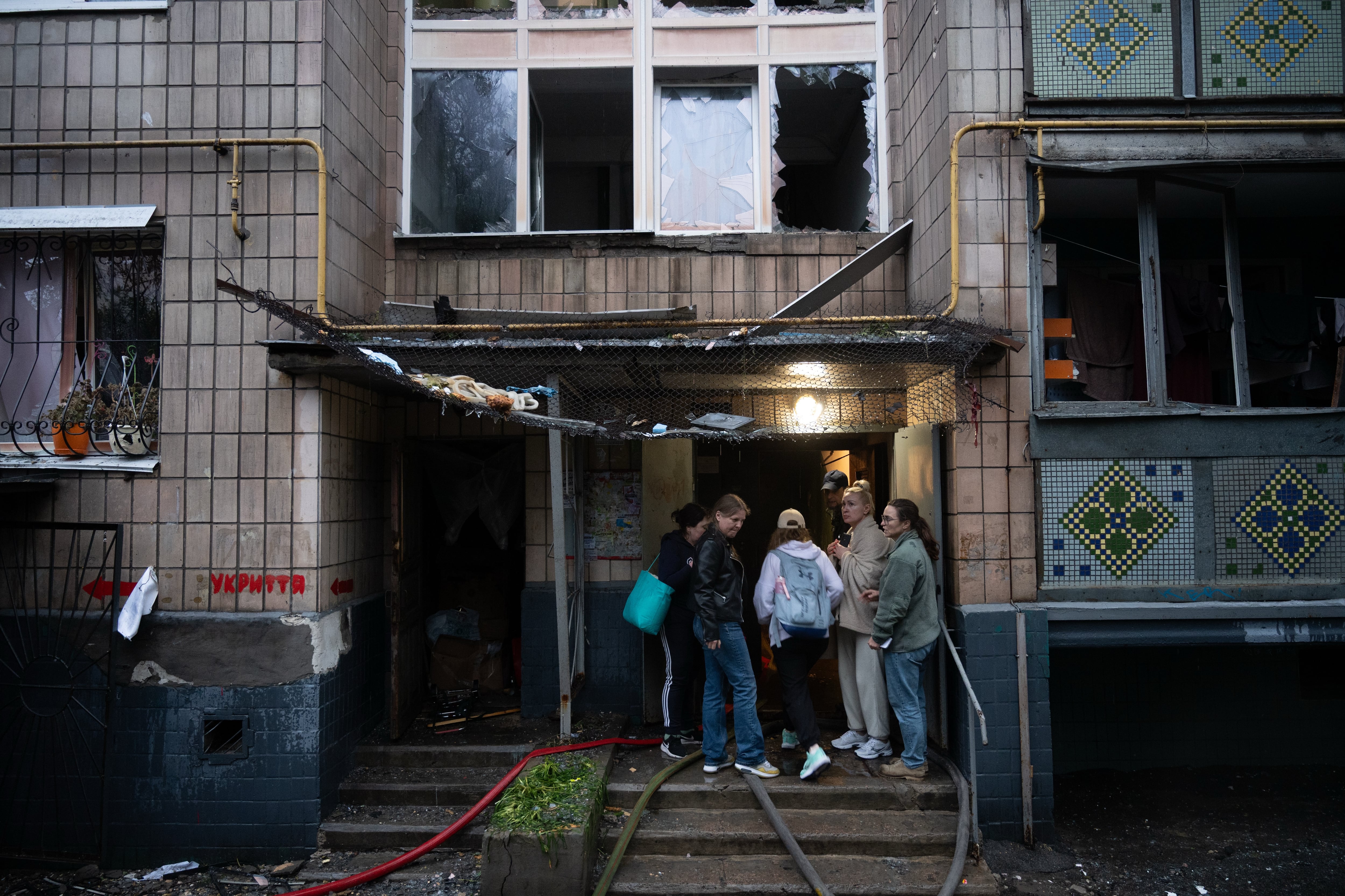 Residentes de Kiev se agolpan frente a un edificio dañado por el ataque ruso. El bombardeo masivo se produjo horas después del anuncio del acuerdo entre Estados Unidos e Irán para poner fin a la guerra en Oriente Medio. (AP Photo/Danylo Antoniuk)