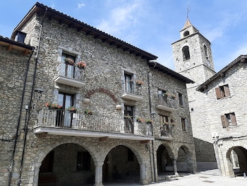 Edificios grises empedrados y de fondo el campanario de la iglesia