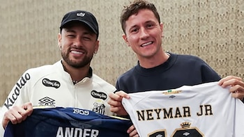 Neymar Jr. y Ander Herrera sonríen a la cámara, cada uno sosteniendo una camiseta de fútbol, la de Neymar con "ANDER" y la de Herrera con "NEYMAR JR"