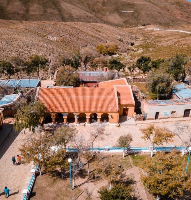 El pueblo de Rinconada, en la provincia de Jujuy, conserva su arquitectura tradicional frente a una plaza arbolada al pie de los cerros.